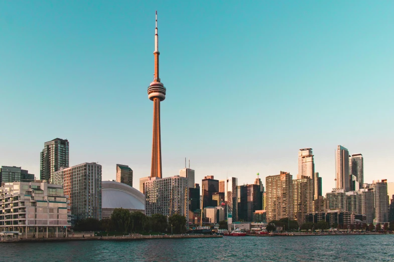 a large body of water with tall buildings in the background, by Carey Morris, pexels contest winner, hurufiyya, cn tower, brown, promo image, realistic photo of a town