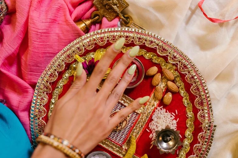 a close up of a person holding a plate with food on it, hindu ornaments, nails, thumbnail, wedding