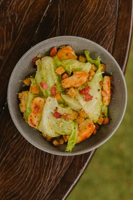 a bowl of food sitting on top of a wooden table, inspired by Pogus Caesar, lettuce, shrimp, puerto rico, square