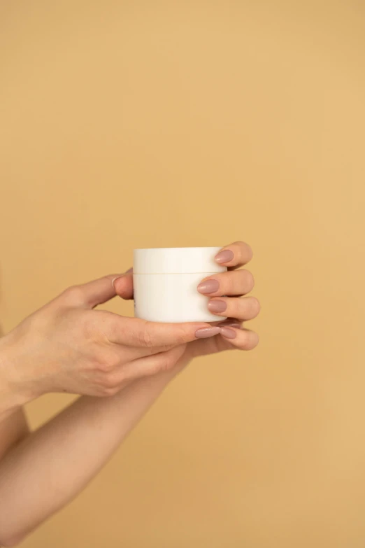 a woman holding a jar of cream in her hands, by Nicolette Macnamara, minimalism, high quality product image”, ceramic base, silicone skin, product introduction photo