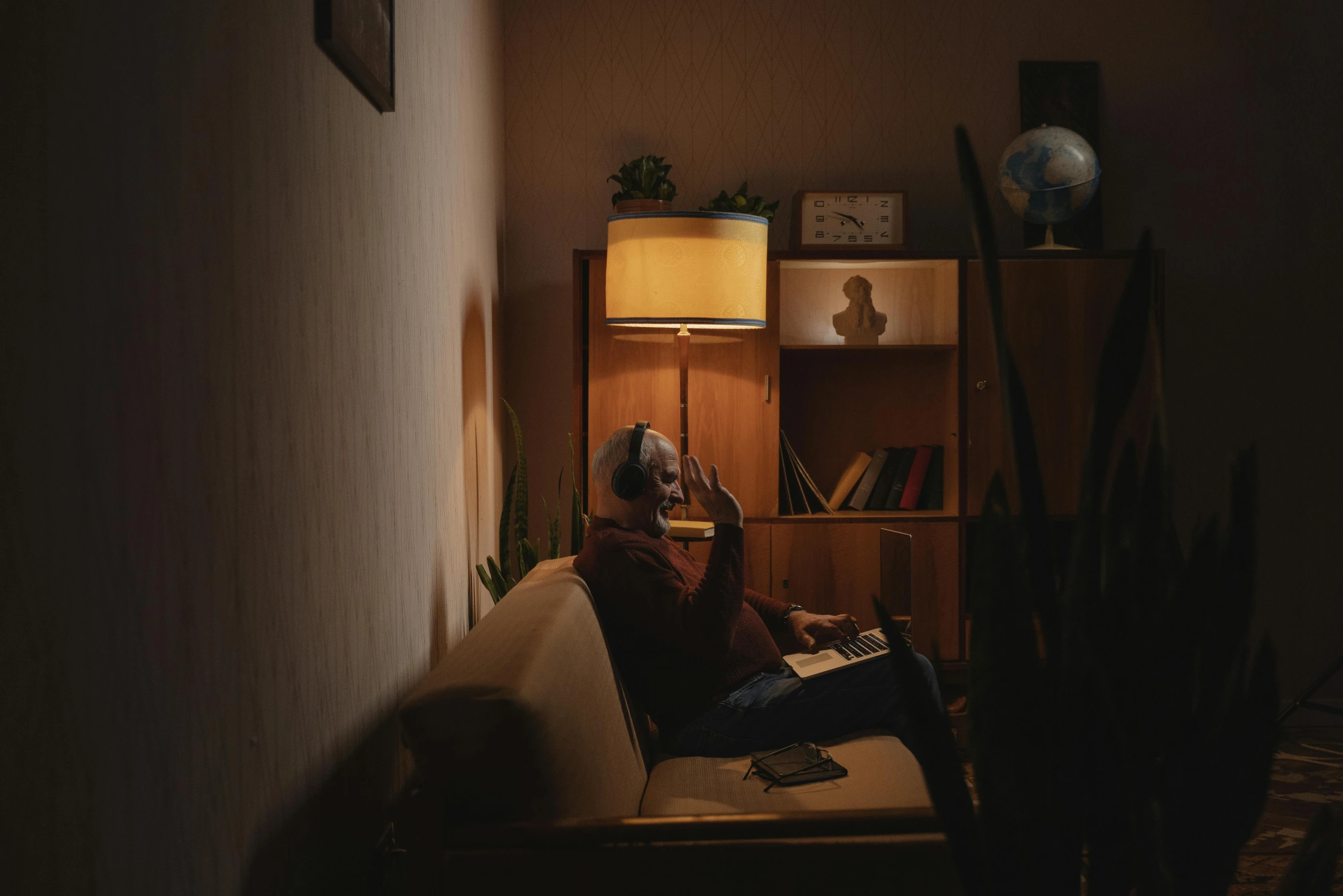 a man sitting on a couch reading a book, an album cover, inspired by Elsa Bleda, pexels contest winner, fantastic realism, magicavoxel cinematic lighting, soviet apartment, old man doing with mask, early night