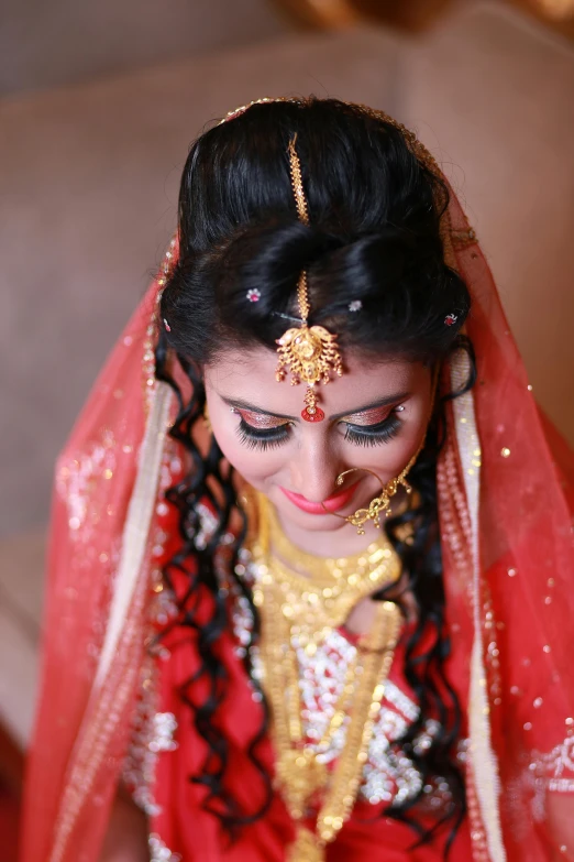 a woman dressed in a red and gold outfit, by Sudip Roy, hurufiyya, close - up on face, bride, assamese, slide show