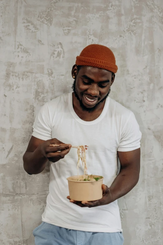 a man holding a bowl of noodles with chopsticks, inspired by Theo Constanté, jaylen brown, profile image, serving body, looking happy