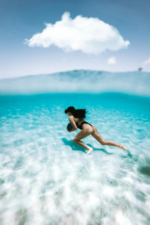 a woman in a bikini swims in the ocean, unsplash contest winner, running and falling on clouds, bahamas, half submerged in heavy sand, 2019 trending photo