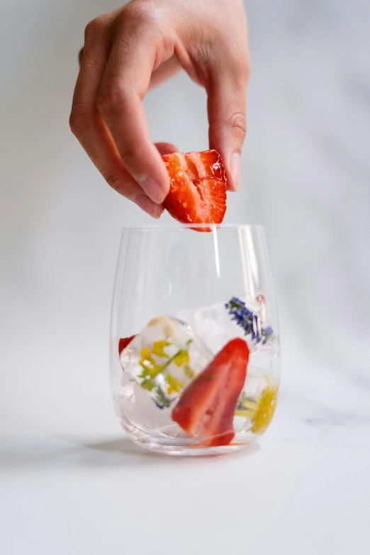 a person holding a piece of fruit in a glass