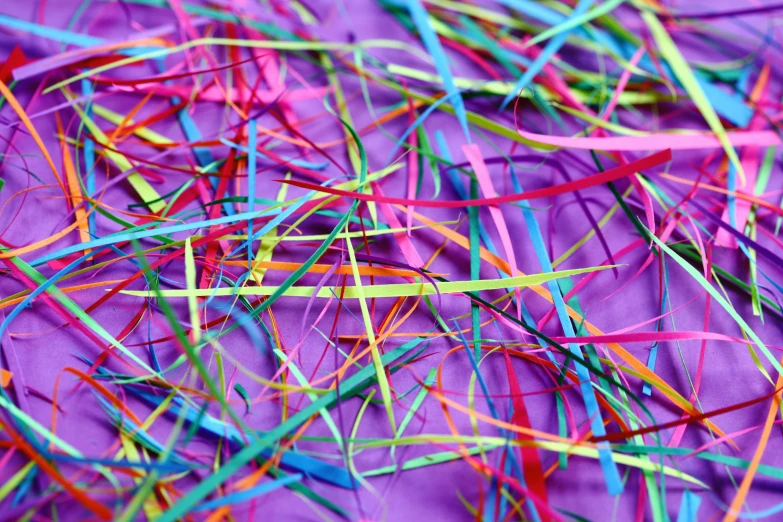 a pile of brightly colored paper on a purple surface, a microscopic photo, by Peter Alexander Hay, pexels, fiberoptic hair, straw, webbing, thin strokes