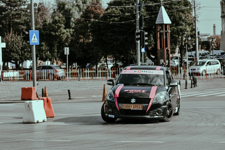 a small car driving down a city street, by Adam Marczyński, pexels contest winner, purism, on a street race track, swift, pink, rally driving photo