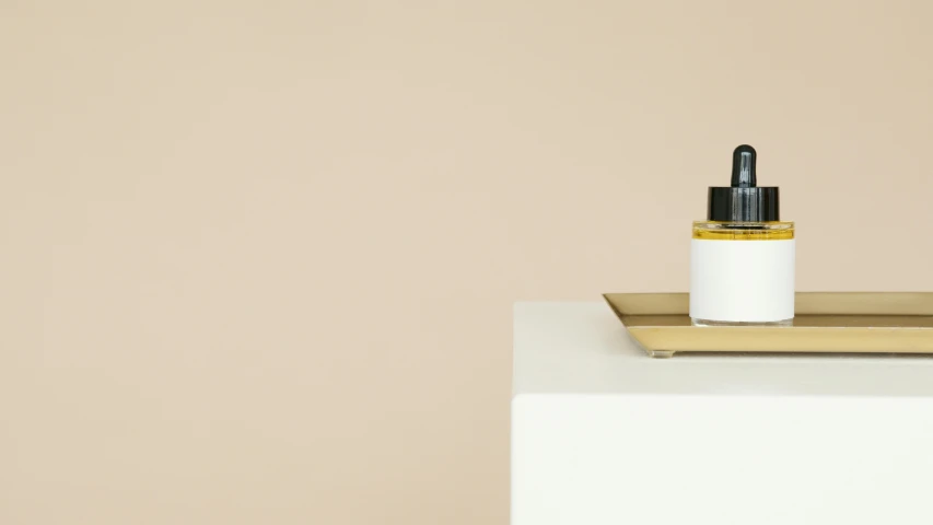 a bottle of perfume sitting on top of a table, inspired by Frederick Hammersley, minimalism, ochre, kirsi salonen, white colors, blushing