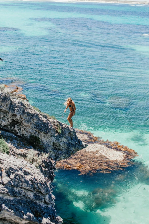 a person jumping off a cliff into the ocean, the emerald coast, rock pools, lush surroundings, traverse