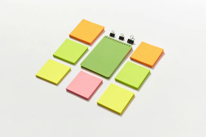 a note pad sitting on top of a pile of post it notes, product view, 8, square, multiple lights