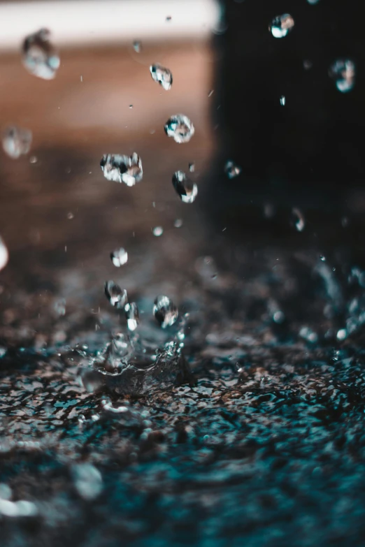 a close up of water pouring from a faucet, an album cover, by Robbie Trevino, pexels contest winner, puddles of water on the ground, pixelated rain, dust particle, rainy evening
