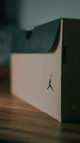 a box sitting on top of a wooden table, by Jesper Knudsen, unsplash, “air jordan 1, on textured base; store website, stick and poke, avatar image