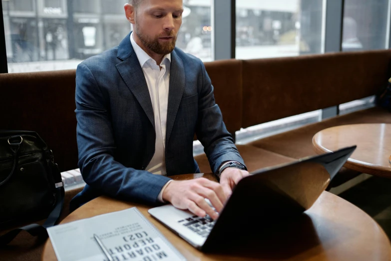 a man sitting at a table working on a laptop, by Carey Morris, pexels contest winner, wearing business casual dress, lachlan bailey, wearing a business suit, thumbnail