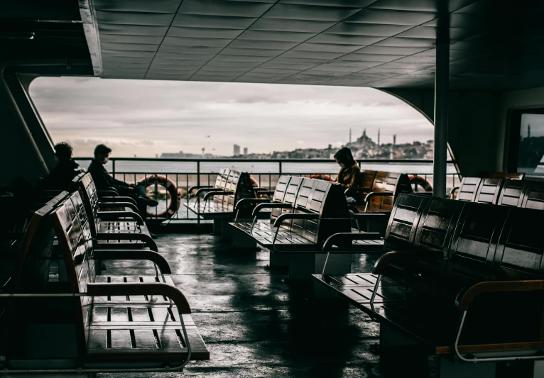 a couple of people sitting on top of a boat, inside on a rainy day, terminal, top selection on unsplash, istanbul