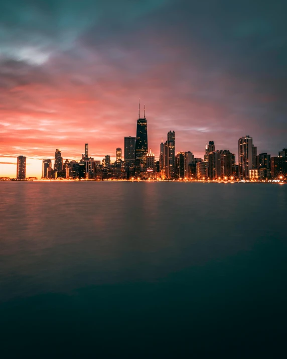 a large body of water with a city in the background, by Jacob Burck, pexels contest winner, fading rainbow light, chicago, background image, journalism photo