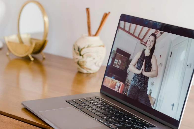 a laptop computer sitting on top of a wooden desk, by Julia Pishtar, unsplash, video art, dance meditation, asian female, background image