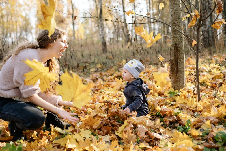 a woman and a child are playing in the leaves, by Maksimilijan Vanka, pexels, avatar image