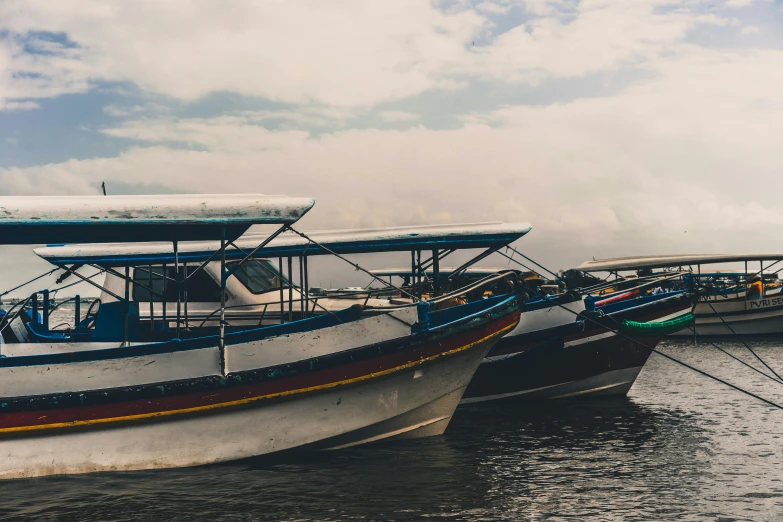 a number of boats in a body of water, a photo, by Carey Morris, pexels contest winner, sumatraism, side profile shot, various colors, grey, thumbnail