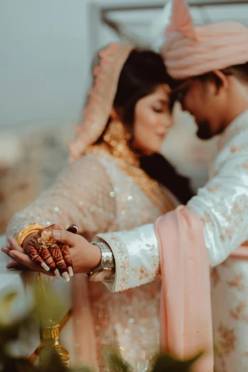 a man and woman standing next to each other, pexels contest winner, hindu aesthetic, romantic themed, holding gold, muslim
