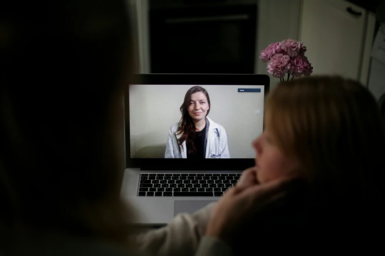 a woman sitting in front of a laptop computer, a portrait, by Meredith Dillman, hurufiyya, doctors mirror, with a long, emily rajtkowski, ap news photo