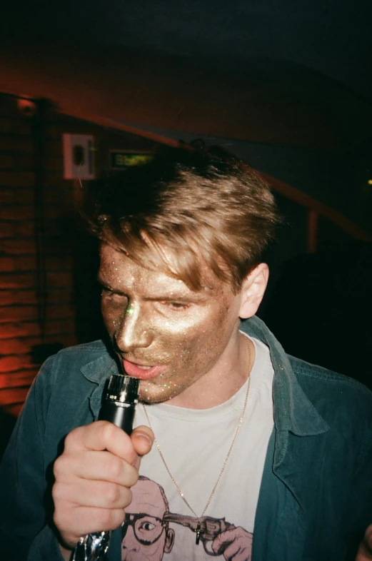 a man that is holding a bottle in his hand, by Lee Gatch, reddit, renaissance, gold eyeshadow, lsd face, party, face mask