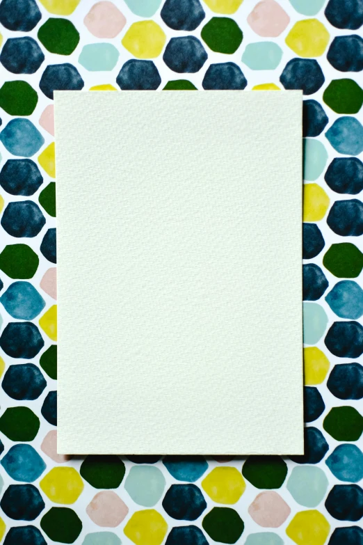 a piece of paper sitting on top of a table, inspired by Kenneth Noland, unsplash, color field, hexagonal pattern, pale milky white porcelain skin, bright castleton green, card frame