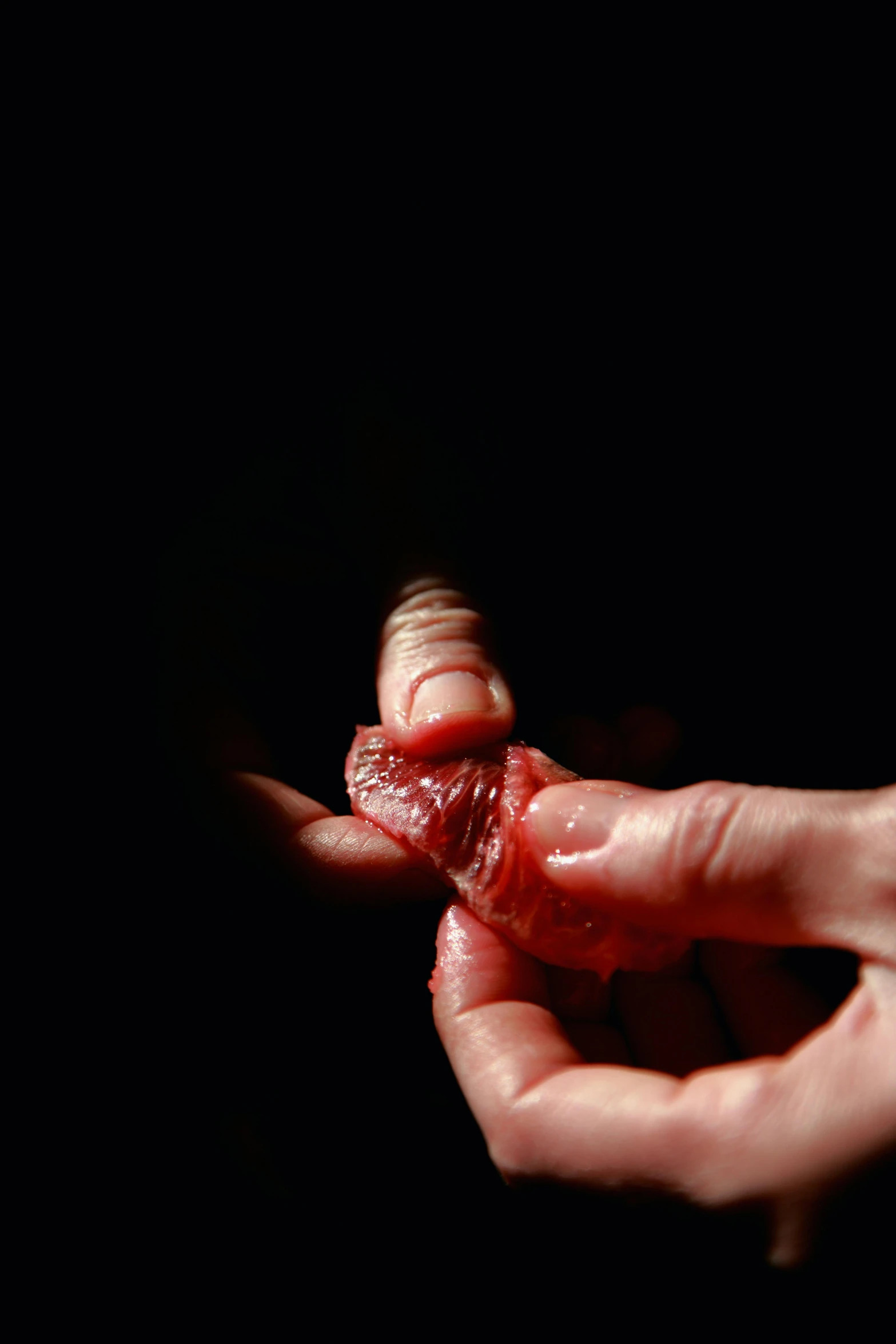 a person holding a piece of meat in their hand, by Adam Chmielowski, wound, on black background, cervix awakening, medium-shot