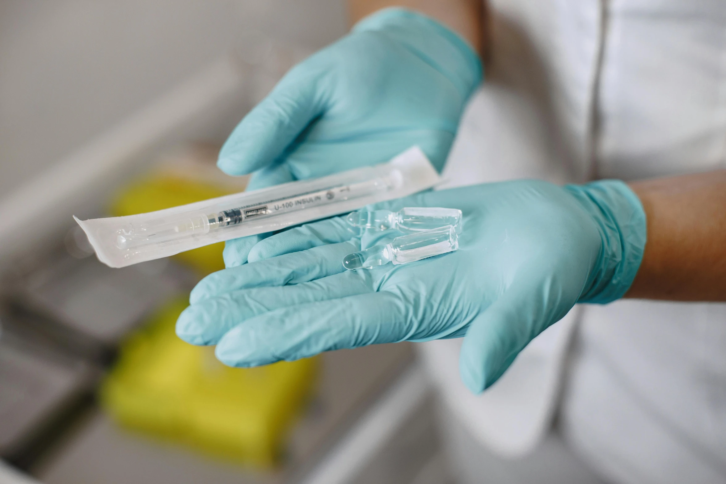 a person in a white shirt and blue gloves holding a tube, syringes, background image, multiple stories, surgical equipment