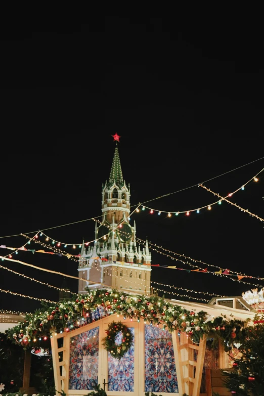 a christmas market with a clock tower in the background, an album cover, inspired by Vasily Surikov, trending on unsplash, socialist realism, kremlin, lines of lights, full frame image, promo image