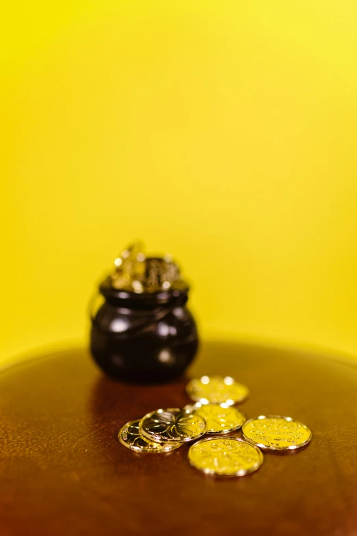 a pot of gold coins sitting on top of a table, by Julia Pishtar, yellow and black, medium shoot, 8, vanilla