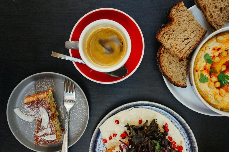 a table topped with plates of food and a cup of coffee, by Lee Loughridge, pexels contest winner, brown bread with sliced salo, thumbnail, grey, small hipster coffee shop