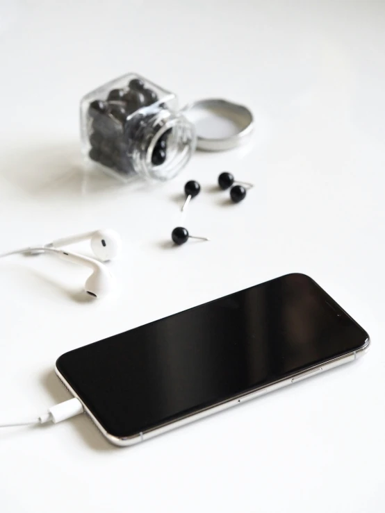 a cell phone sitting on top of a white table, an album cover, pexels, earbuds jewelry, black theme, no - text no - logo, profile image