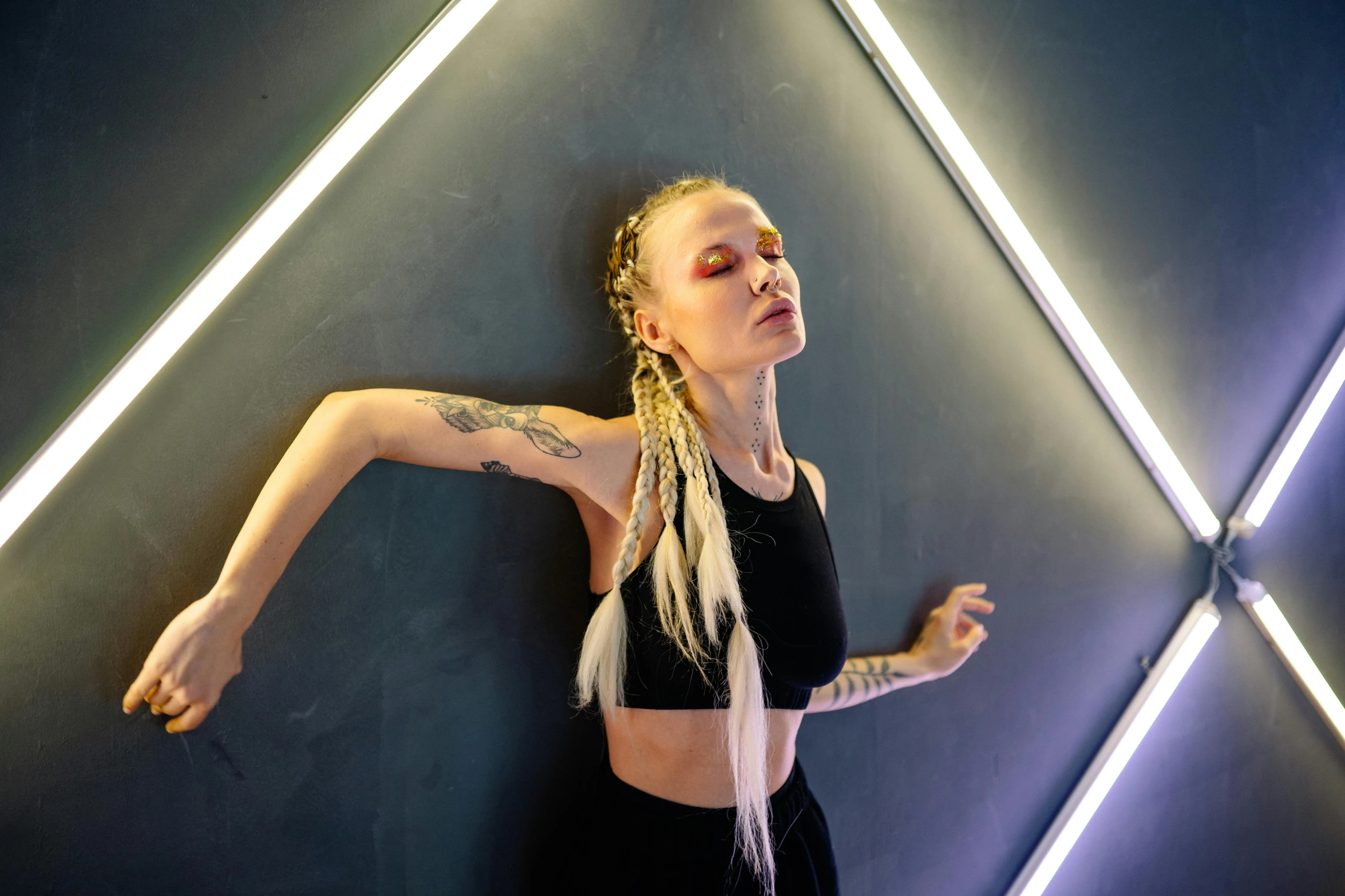 a woman standing in front of a wall with neon lights, an album cover, pexels contest winner, light and space, female dancer, tattooed, youtube thumbnail, anna podedworna