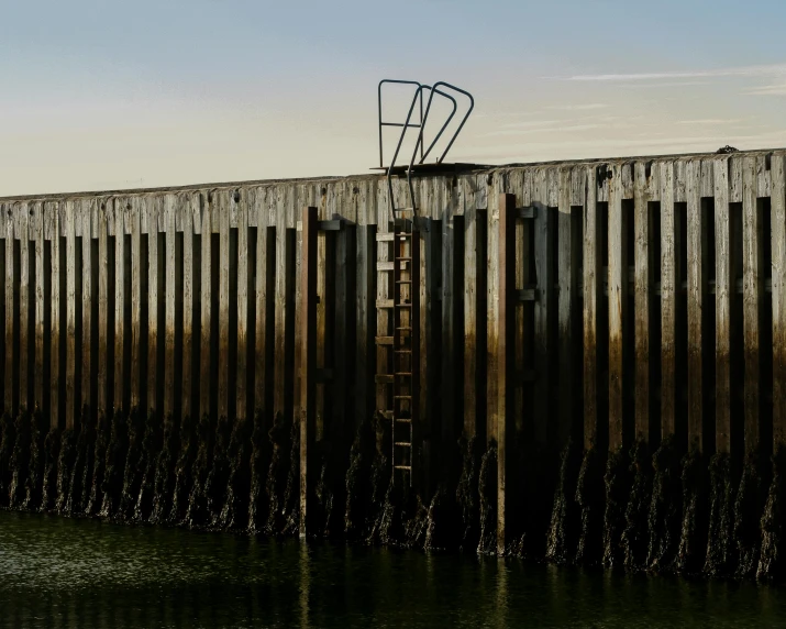 a boat sitting on top of a body of water, by Peter Churcher, pexels contest winner, minimalism, ladders, maryport, late afternoon, a portal to the depths