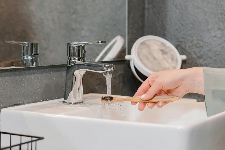 a person washing their hands in a bathroom sink, by Julia Pishtar, trending on pexels, stipple brush, holding a wooden staff, drooling ferrofluid, profile image