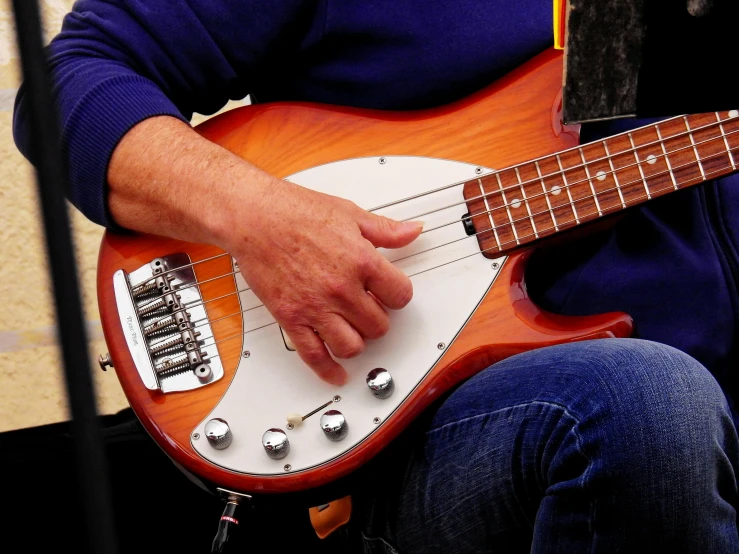 a close up of a person playing a guitar, by Tom Phillips, pixabay, bass drum, slightly tanned, holding a silver electric guitar, hr ginger