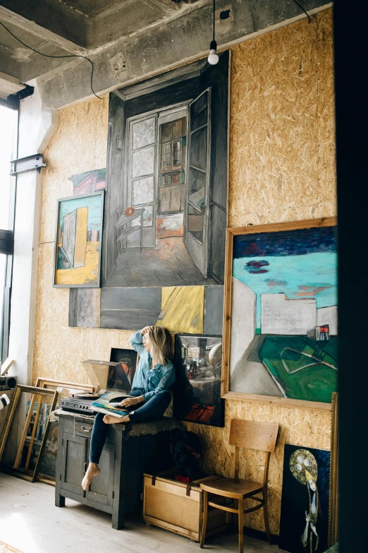 a woman sitting on a bench in front of a painting, a painting, trending on unsplash, arbeitsrat für kunst, in his basement studio, working, next to a big window, chalk