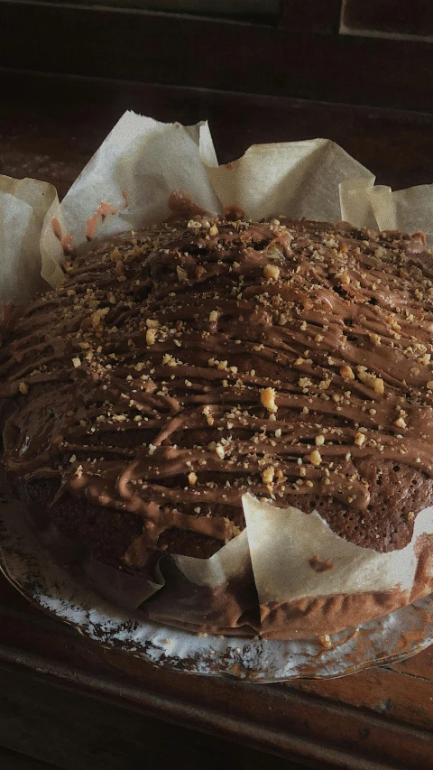 a chocolate cake sitting on top of a wooden table, pexels, hurufiyya, square, ap, a messy, brown:-2