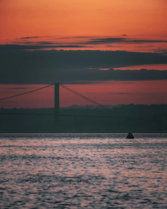 a large body of water with a bridge in the background, inspired by Elsa Bleda, unsplash contest winner, sunsetting color, lisbon, mermaid in distance, lgbtq