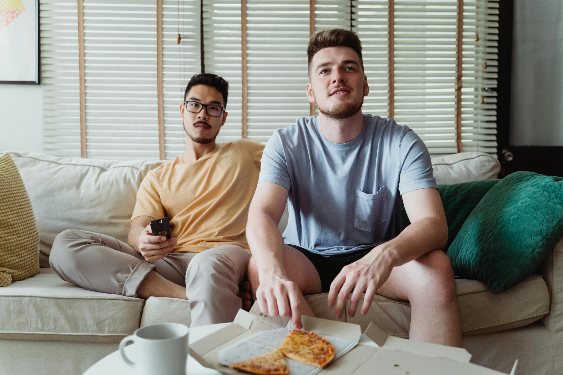 two men sitting on a couch eating pizza, by Adam Marczyński, pexels, eating chips and watching tv, aussie baristas, edmund blair and charlie bowater, gray men