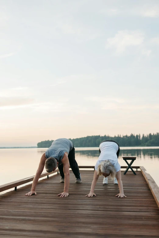 two people doing a handstand on a dock, by Jessie Algie, finland, morning time, laying down with wrists together, profile image