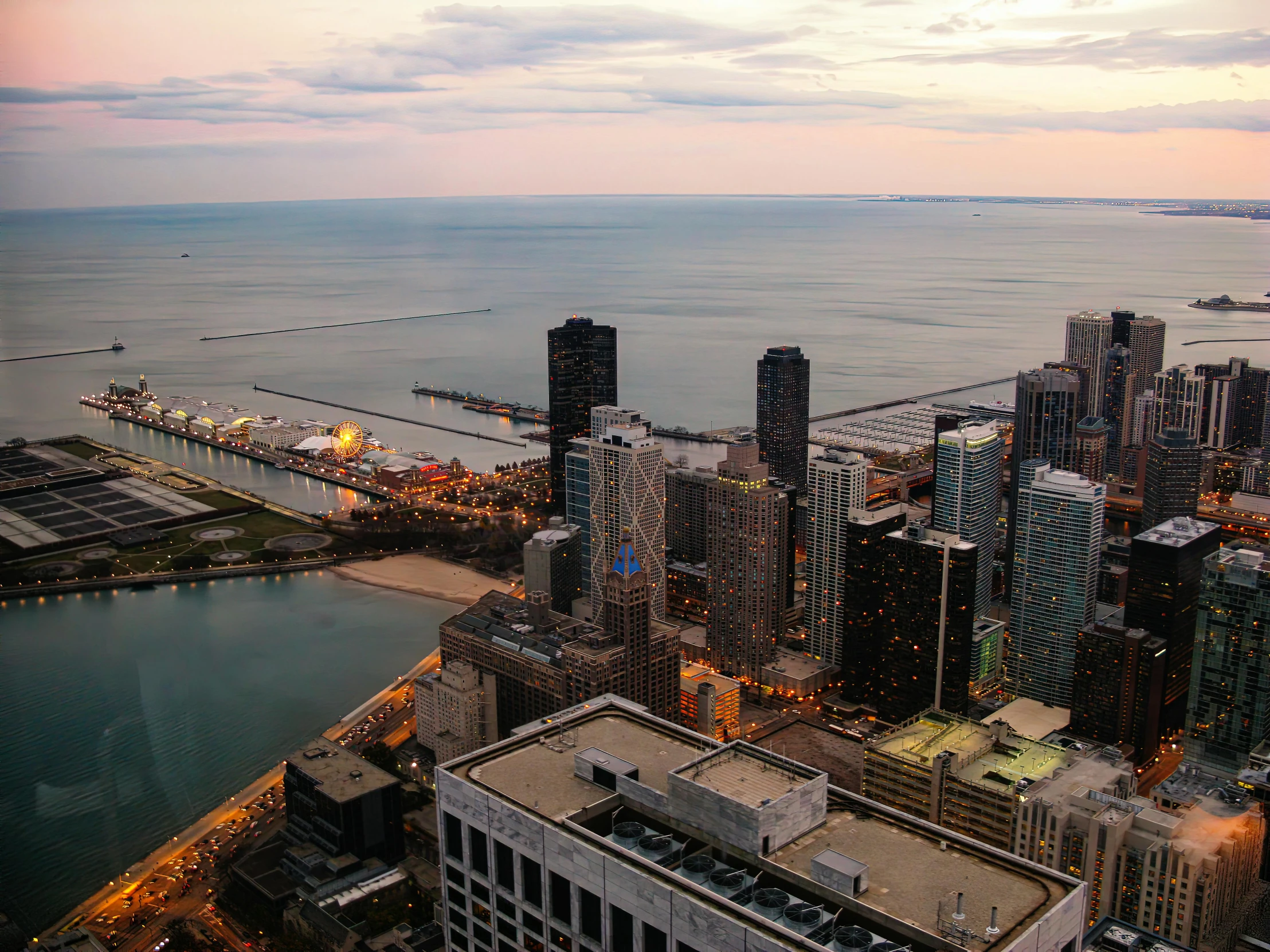 a view of a city from the top of a building, chicago skyline, the sea seen behind the city, city sunset, nature photo