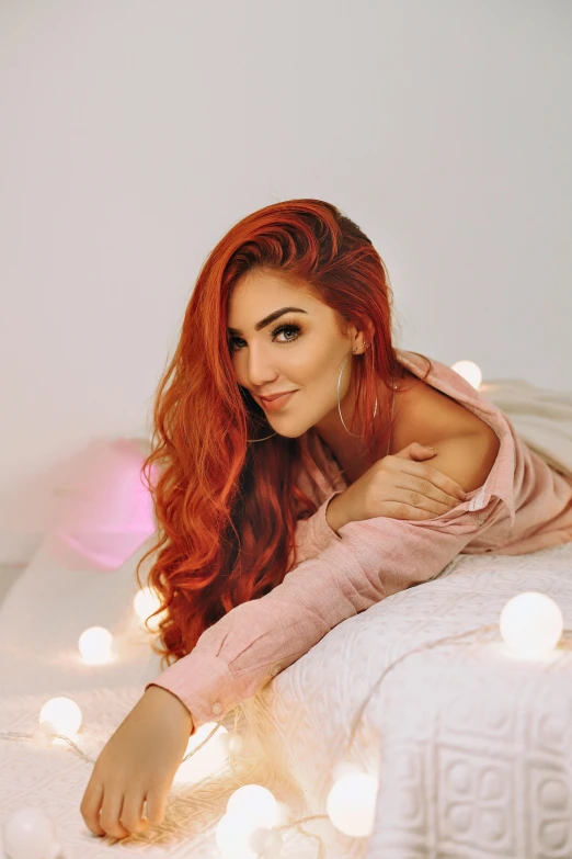 a woman laying on top of a bed covered in lights, inspired by Julia Pishtar, red long wavy hair, irish youtuber, alanis guillen, gif