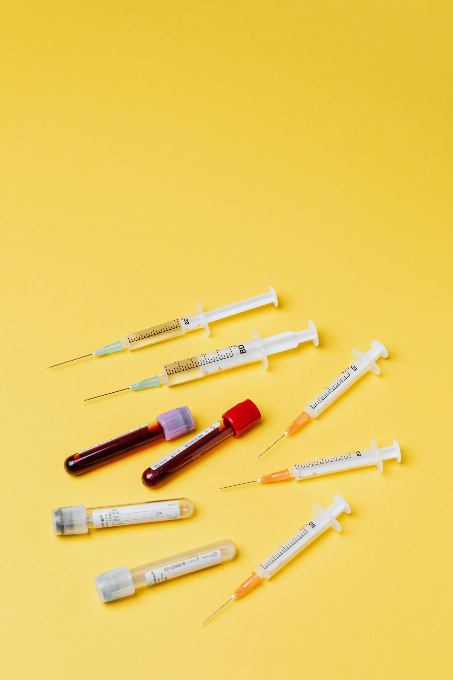 a bunch of syops sitting on top of a yellow surface, trending on pexels, plasticien, holding syringe, detailed product image, various sizes, opening shot