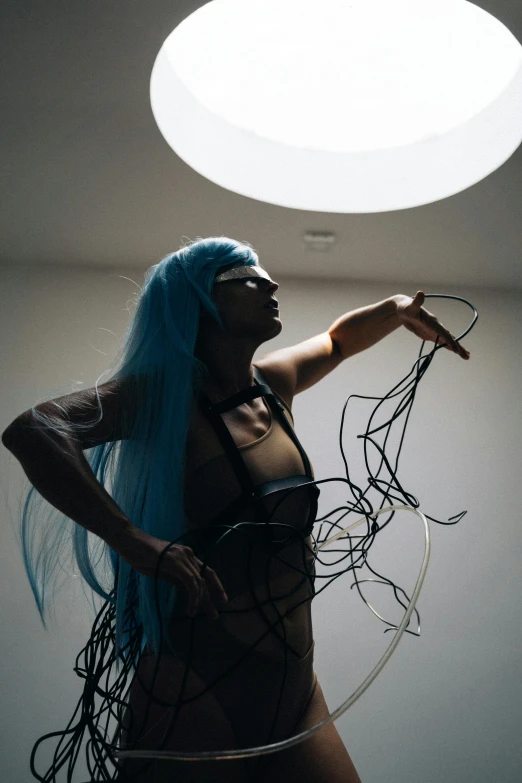 a woman with blue hair standing under a light, inspired by Hans Bellmer, unsplash, kinetic art, pvc poseable, tangled wires, sexy pudica pose gesture, photo of a black woman