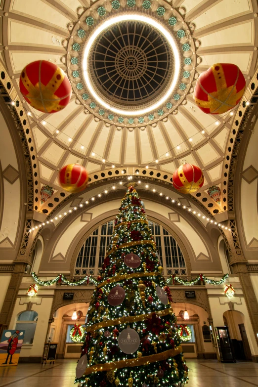 a large christmas tree sitting inside of a building, inspired by Sydney Prior Hall, with great domes and arches, british columbia, square, inside a casino