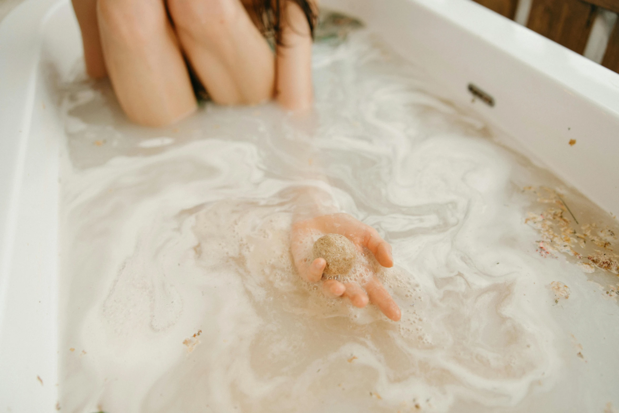 a person washing their hands in a tub of water, a marble sculpture, by Emma Andijewska, trending on pexels, freckles on chicks, floating dust, bumps, 1 4 9 3