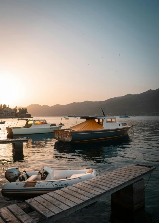 a couple of boats sitting on top of a body of water, by Tobias Stimmer, pexels contest winner, gold hour light, boka, small port village, genzoman