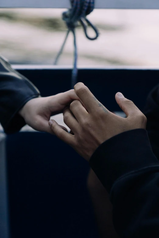 a close up of a person holding a cell phone, inspired by Nan Goldin, unsplash, romanticism, on a boat, holding hands, couple, ( ( theatrical ) )