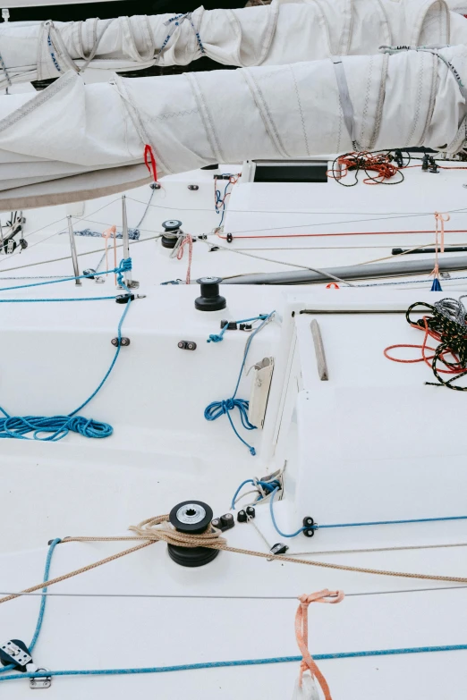 a white sail boat sitting on top of a body of water, exposed wiring and gears, overhead shot, panoramic shot, high-quality photo